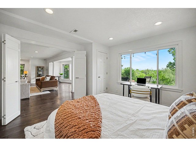 Property Photo 17 Elegant double doors open up this spacious bedroom directly to the main living area, creating a flexible layout that's perfect for a wide-open home office, an extended family room, or a private guest suite.