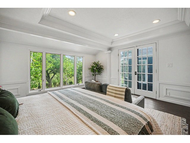Property Photo 14 Wake up to spectacular views! The luxurious primary suite features elegant French doors that open directly to the private back patio, seamlessly connecting your indoor sanctuary with the peaceful, tree-lined backyard oasis.