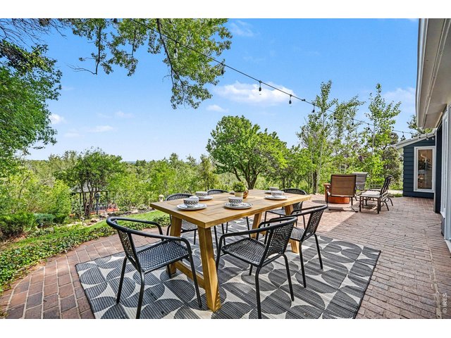 Property Photo 24 Enjoy peaceful morning coffee or evening gatherings on this beautiful brick patio. Seamlessly connecting to the indoor dining space, it offers panoramic, elevated views of your lush backyard oasis leading to the river.