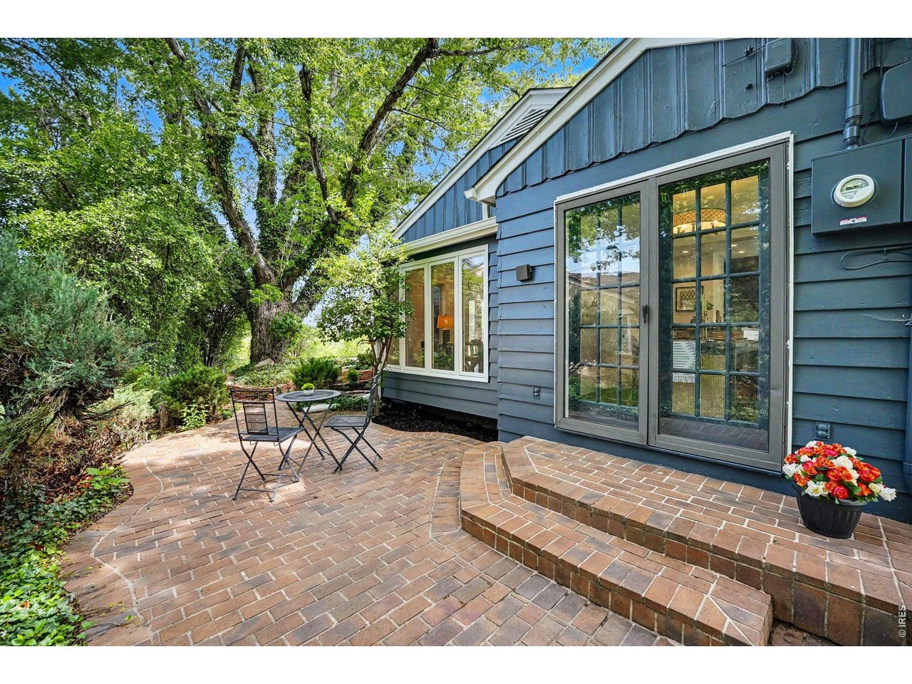 A peaceful retreat right outside your door. This private brick courtyard patio sits just off the dining space, framed by mature trees and lush greenery-the perfect spot for a bistro set and your morning coffee