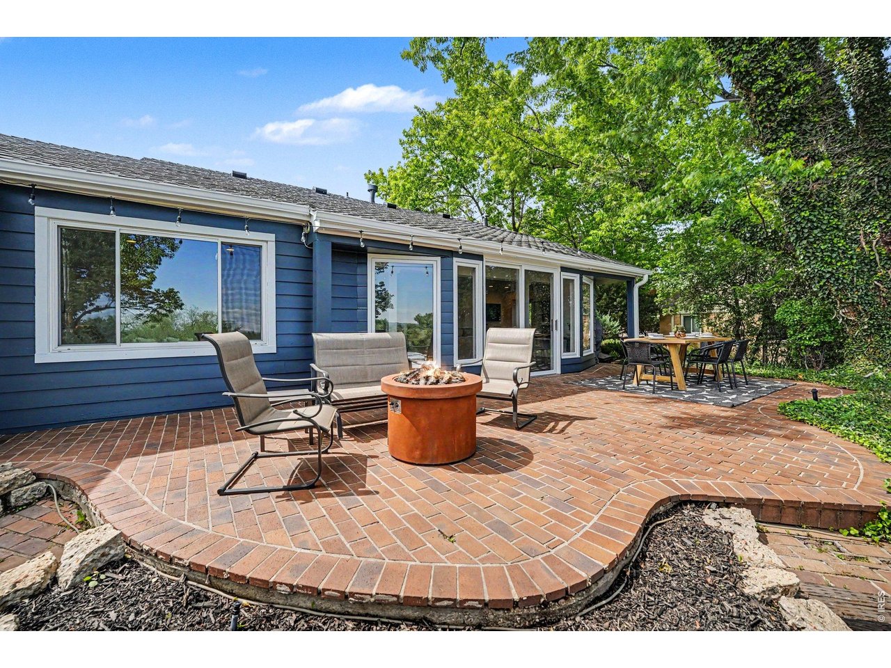 Breathtaking backyard oasis. Features festive bistro lighting, and a seamless connection to indoor living.