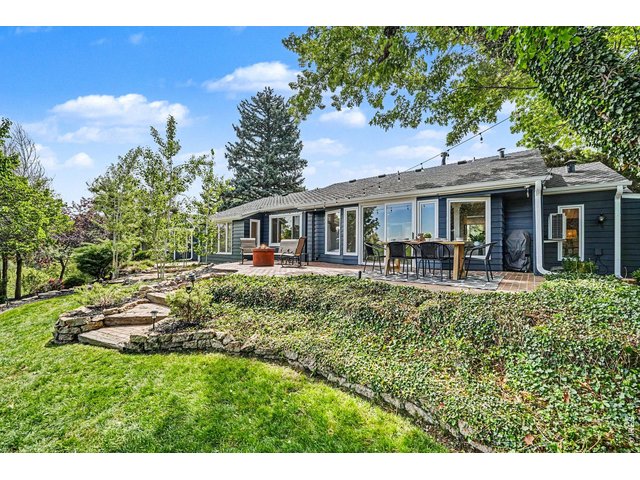 Property Photo 28 Stunning terraced lawn featuring custom stone staircases, detailed rock garden beds, and massive mature trees creating a peaceful, shaded oasis.