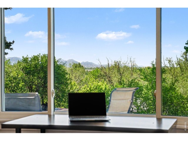 Property Photo 18 Inspiring views from the secondary bedroom, offering a scenic backdrop of greenery and distant mountain peaks.