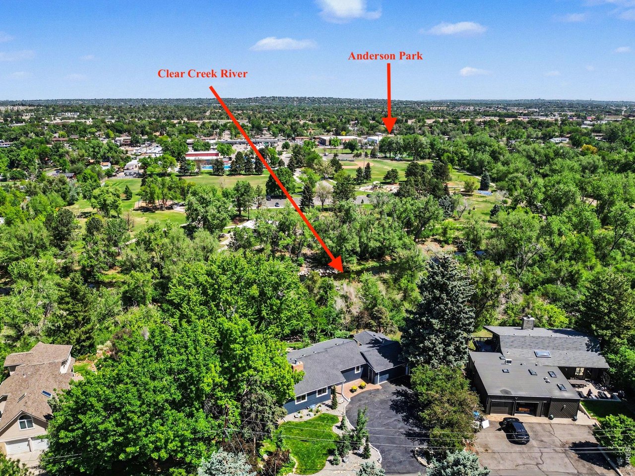 This aerial view highlights the home's beautiful mid-century ranch design, massive tree canopy-all nestled in a prime location across from neighborhood parks.