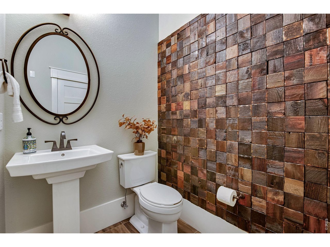 Striking Walnut accent wall in the powder bathroom, all comfortable height toilets.