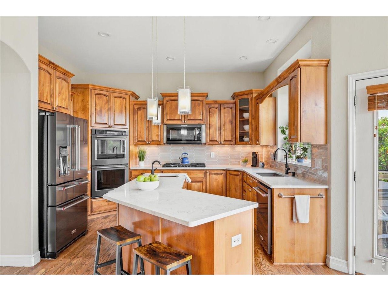 Black stainless steel KitchenAid appliances with double oven and gas range