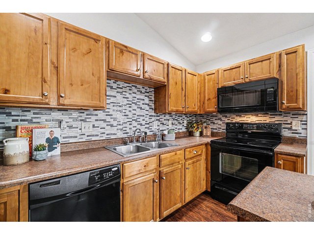 Property Photo 9 Welcoming kitchen with alder cabinets, center island, and a colorful backsplash that adds a touch of character