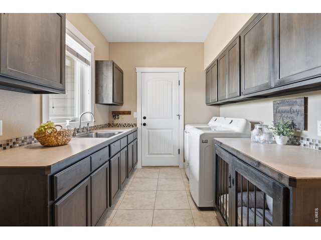 Property Photo 32 Laundry room off of garage with utility sink and cabinets