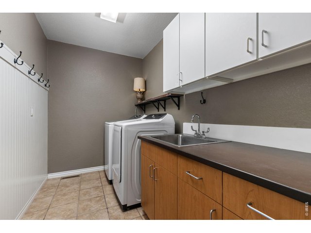Property Photo 20 Large Main Floor Laundry Room with Sink, Counter and Cabinets