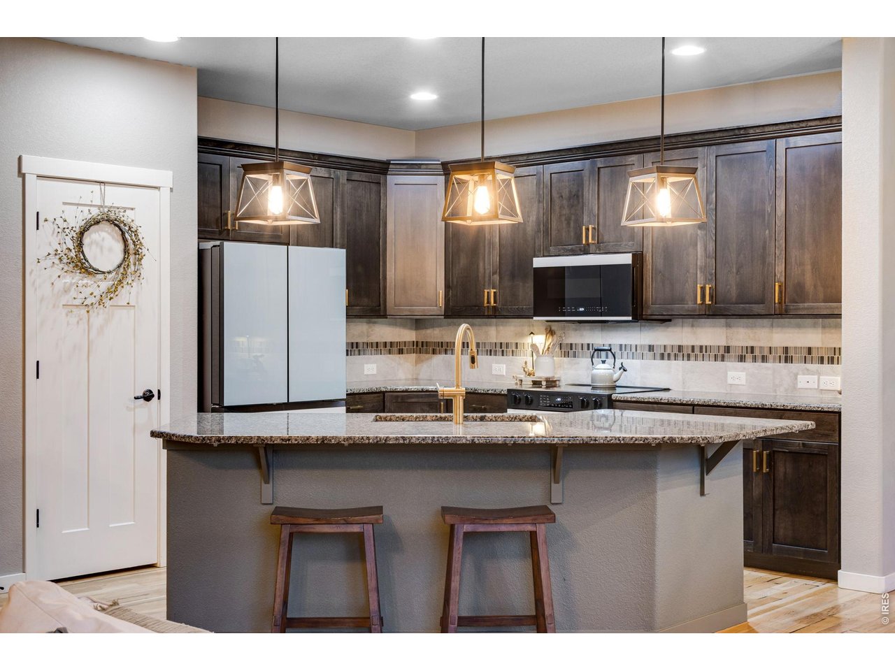Open kitchen features granite slab countertops and a full tile backsplash