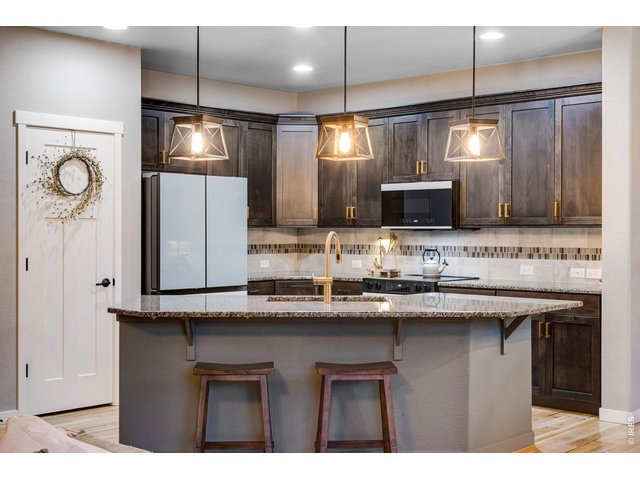 Property Photo 8 Open kitchen features granite slab countertops and a full tile backsplash
