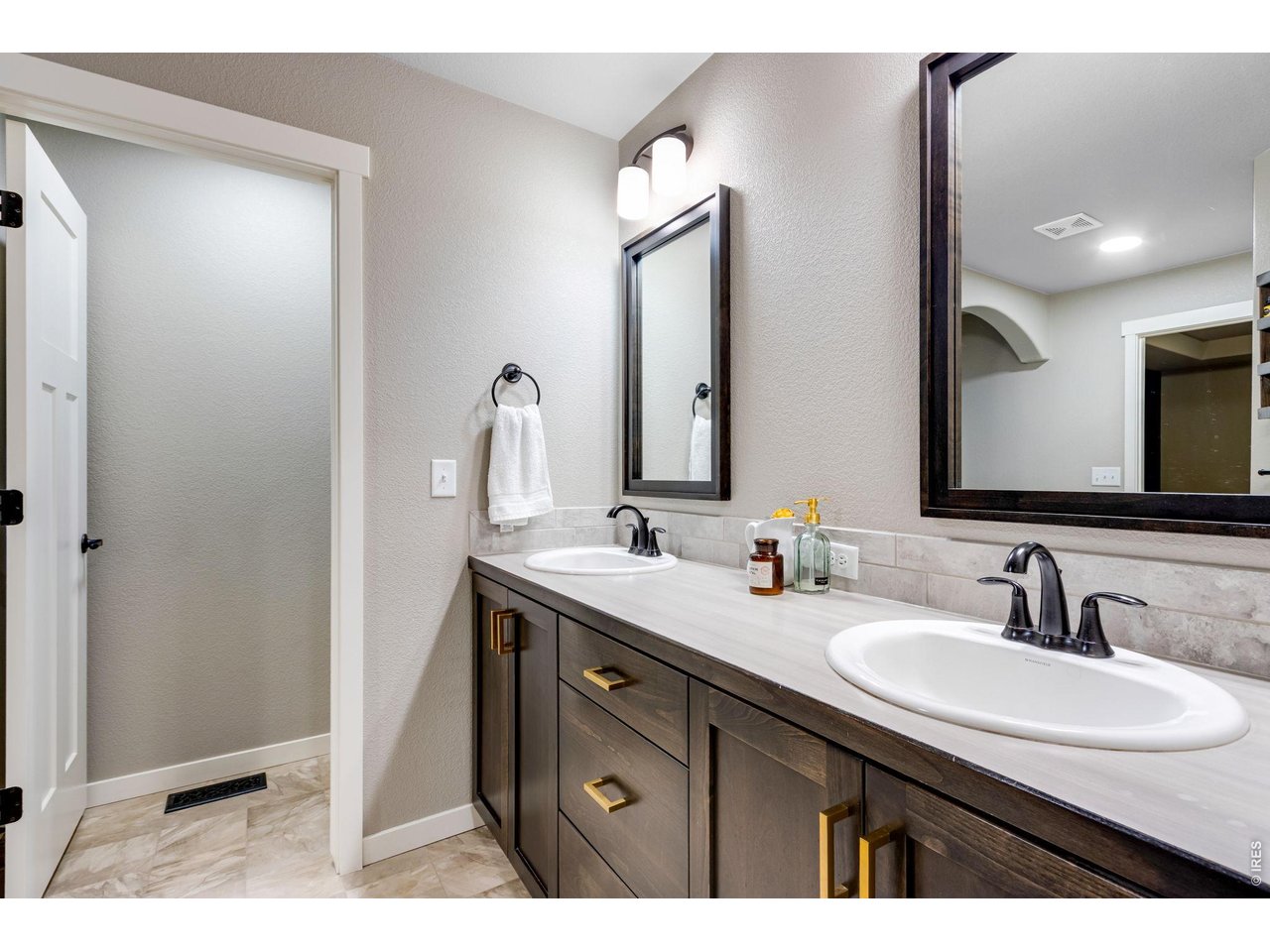 5-piece luxury bath with 2 lifted vanities, upgraded mirrors and light fixtures plus a door to throne