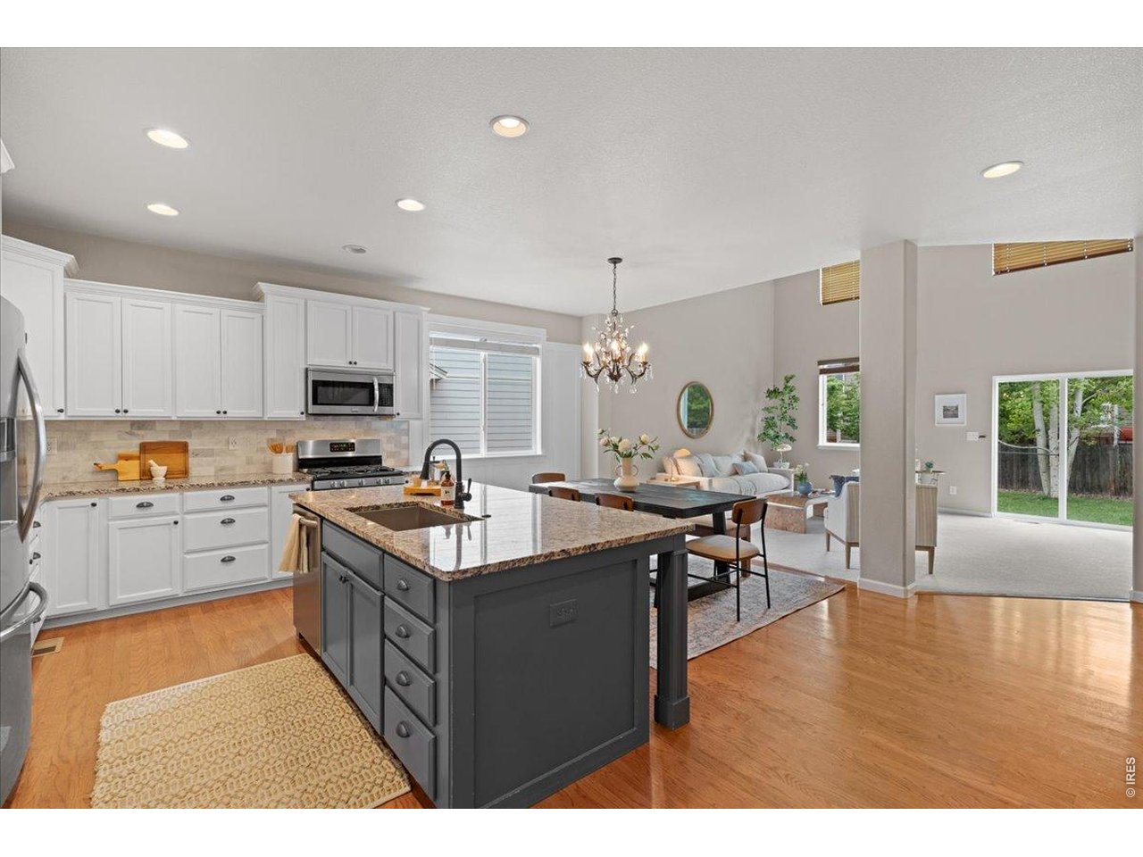 Expansive granite countertops and wood floors throughout the kitchen and dining area