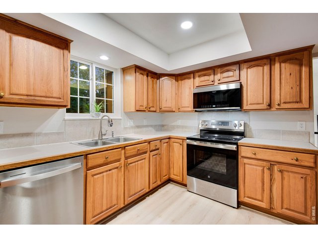 Property Photo 16 Cozy kitchen featuring plenty of Hickory cabinets with hardware and crown molding plus plenty of counter-space, pantry and all stainless-steel appliances which are included