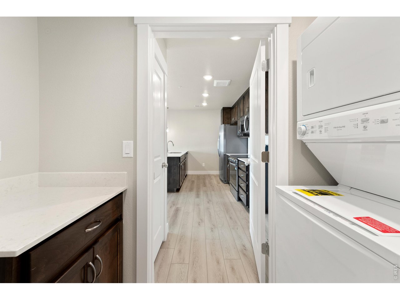 Property Photo 10 Laundry room w/ stackable washer and dryer + built in cabinets w/ quartz countertops.