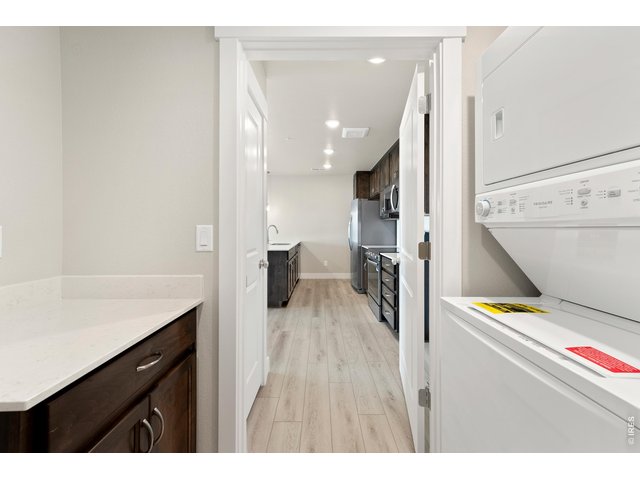 Property Photo 10 Laundry room w/ stackable washer and dryer + built in cabinets w/ quartz countertops.