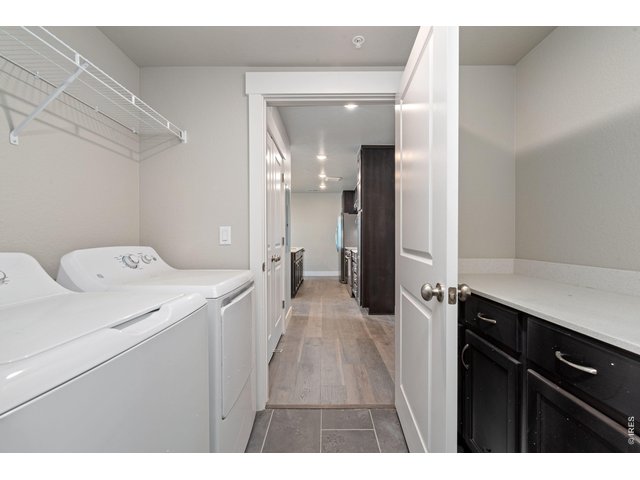 Property Photo 10 Laundry room with washer, dryer and built in cabinets w/ quartz countertops. 