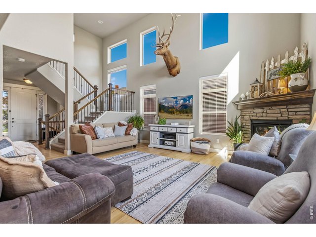 Property Photo 11 Elegant main living room filled with natural light from dramatic two-story windows.