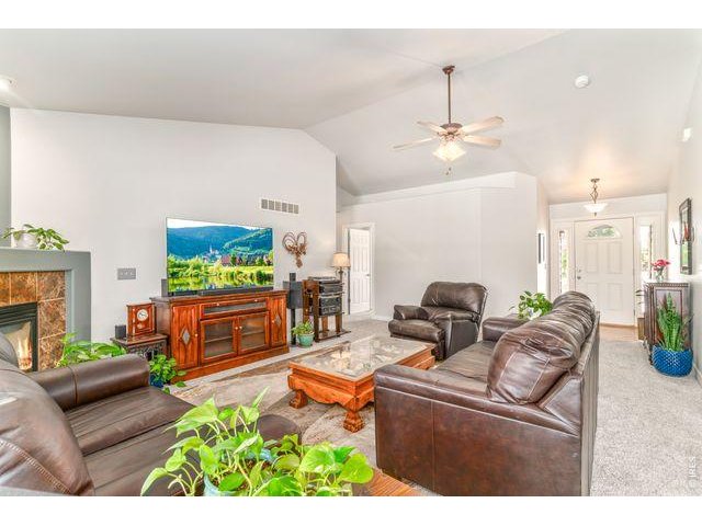 Property Photo 4 Spacious living room has tons of natural light, vaulted ceilings and a corner fireplace for chilly Colorado evenings. 