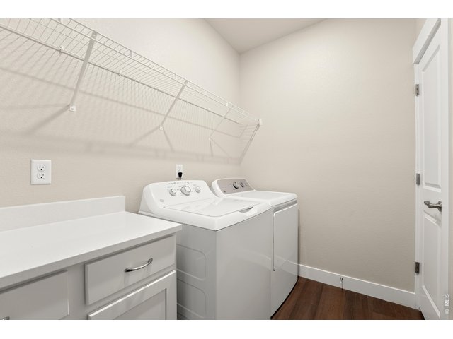 Property Photo 14 Laundry room with washer, dryer, built in cabinets w/ quartz countertop and built in shelving. 