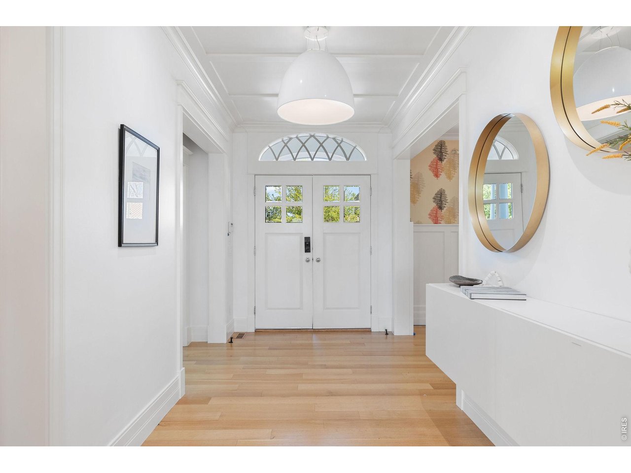 A gracious entry introduces interiors defined by wide-plank oak flooring, soaring ceilings, exquisite millwork, and curated designer lighting. 