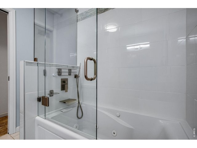 Property Photo 22 one of 2 baths. Note the glass shower door and jetted soaking tub