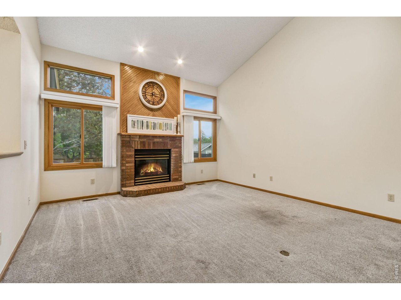 Property Photo 11 vaulted ceilings, abundant natural light, a cozy brick-surround gas fireplace