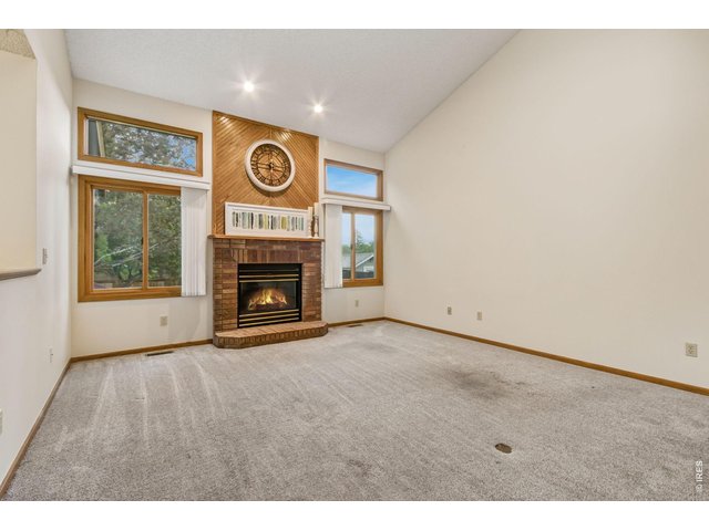 Property Photo 11 vaulted ceilings, abundant natural light, a cozy brick-surround gas fireplace