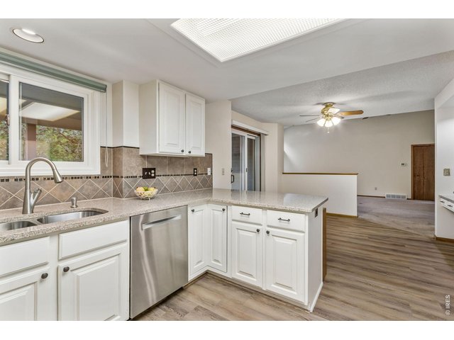 Property Photo 19 Bright and fresh painted cabinets, quartz countertops and a tile backsplash create a modern space. 