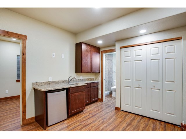 Property Photo 34 Wet bar with mini refrigerator, cabinets, and granite slab countertop