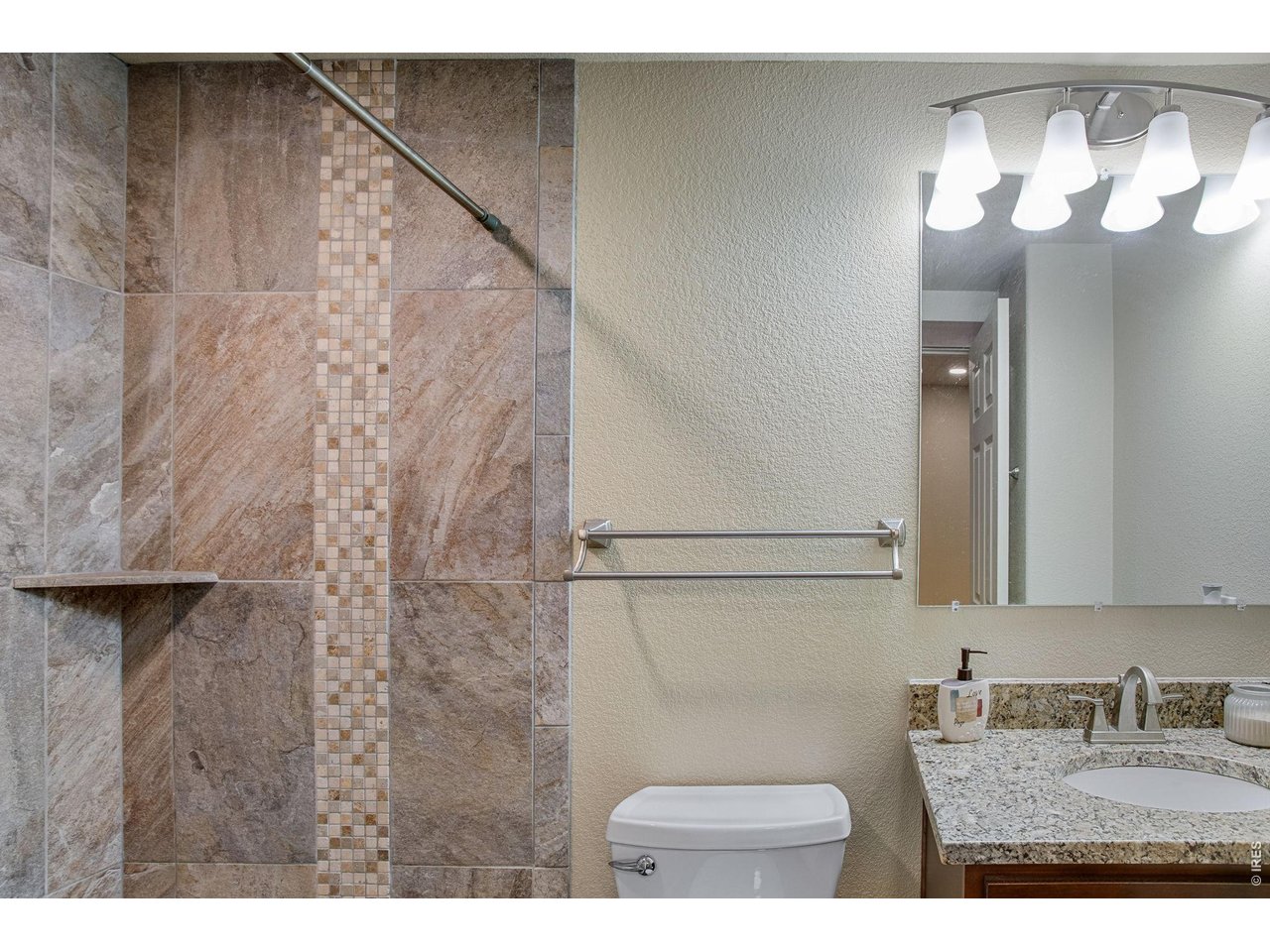 Property Photo 37 bath featuring a vanity with granite slab countertop and shower with full tile backsplash