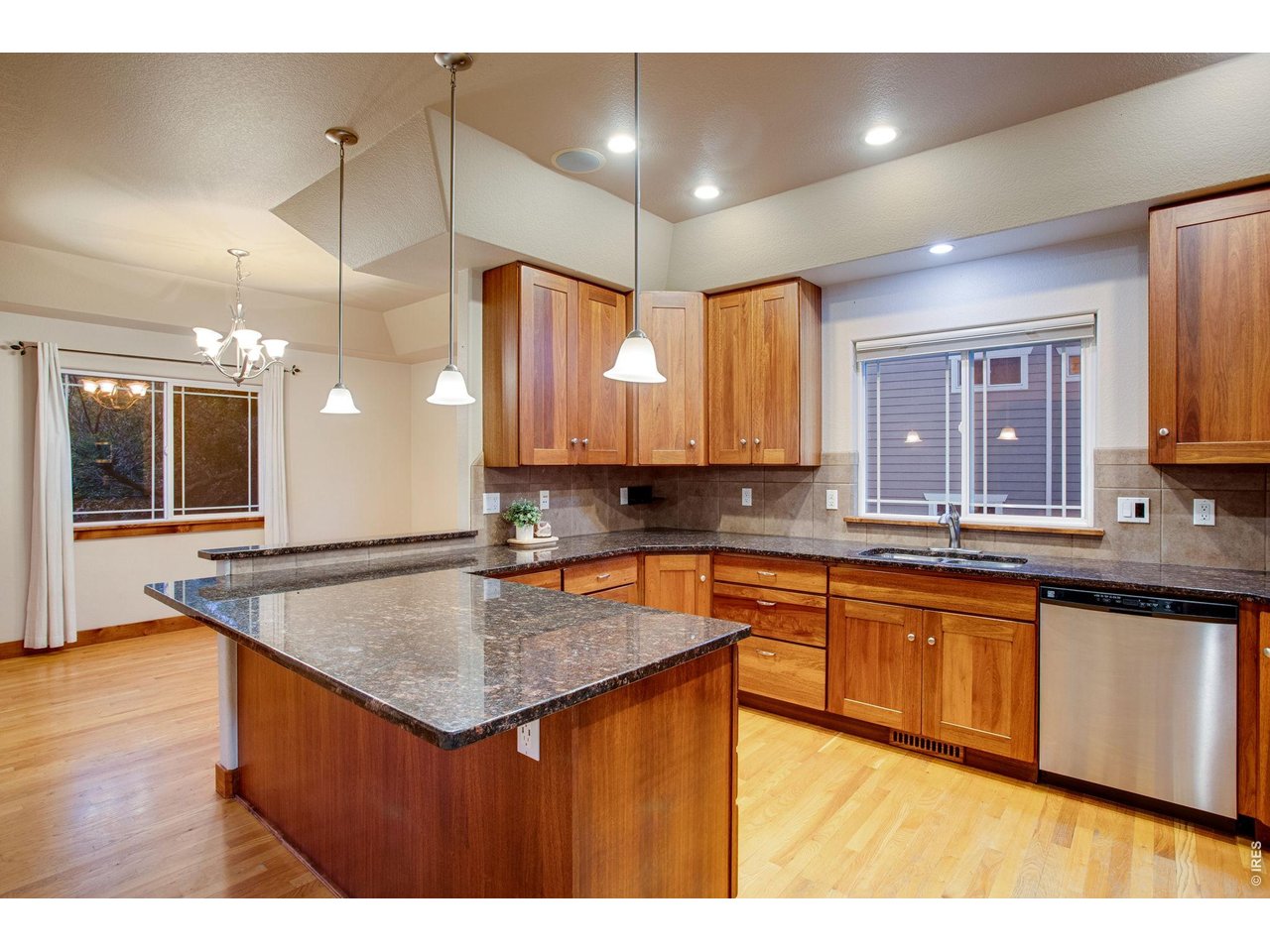 Property Photo 11 Open kitchen features granite slab countertops, breakfast bar, full tile backsplash, plenty of Lyptus cabinets with hardware, two Lazy Susans, and roll-out drawers. 