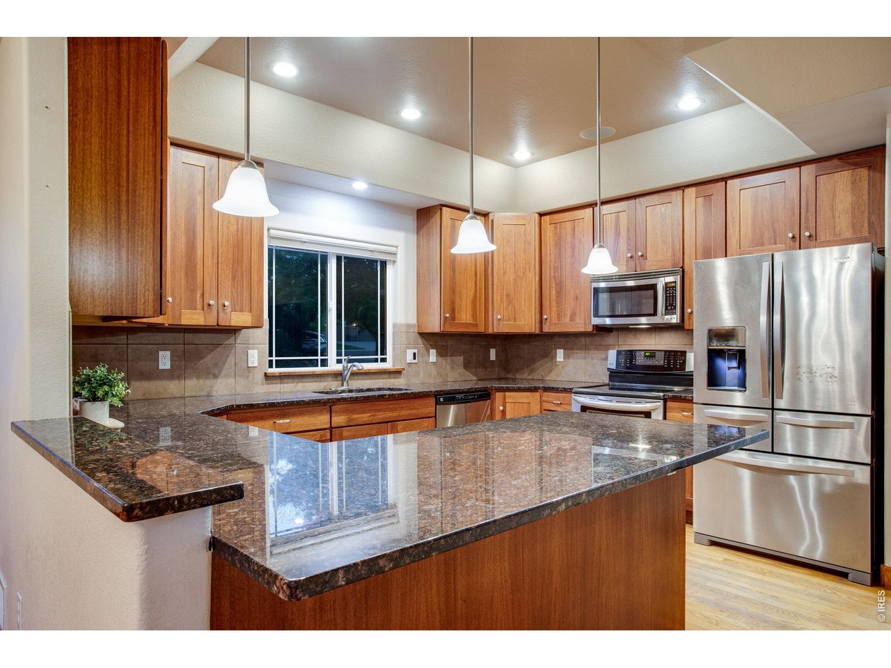 Property Photo 12 Open kitchen features granite slab countertops, breakfast bar, full tile backsplash, plenty of Lyptus cabinets with hardware, two Lazy Susans, and roll-out drawers. 