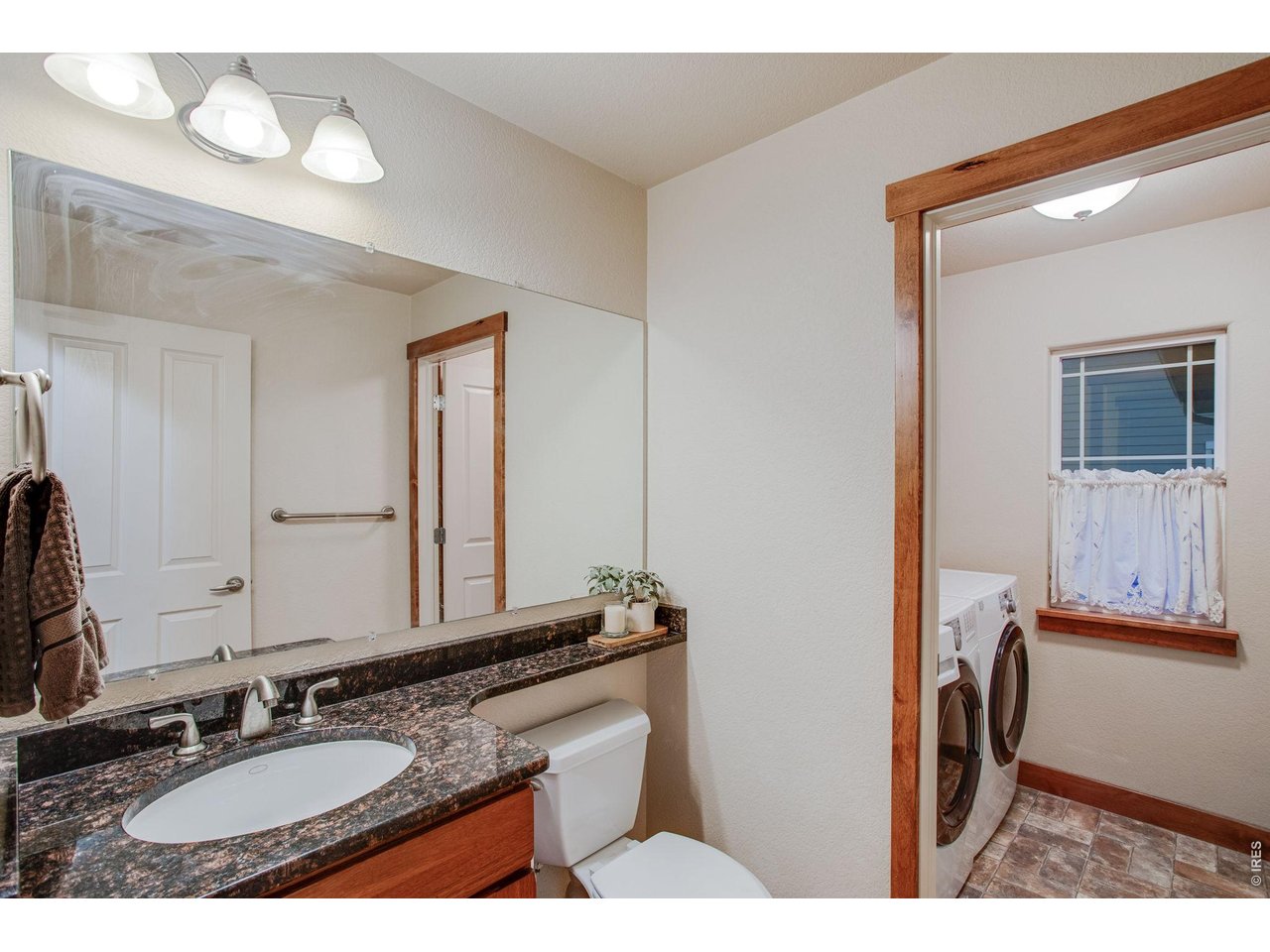 Property Photo 17 Guest half bath features a raised vanity with granite slab countertop & Main floor laundry with cabinets. Clothes washer and clothes dryer are included. 