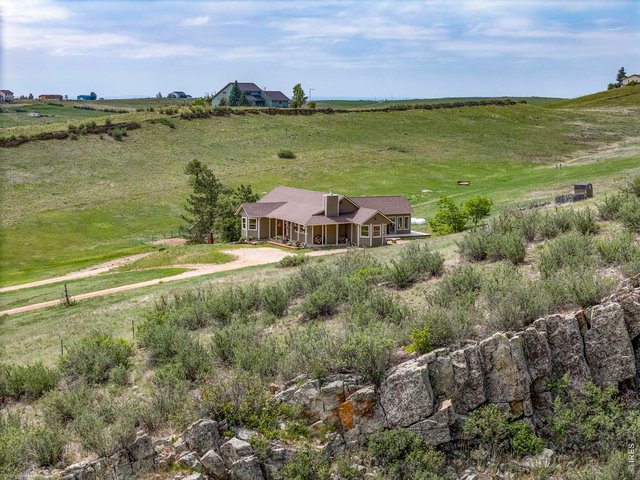 Property Photo 1 Welcome to 5821 W County Road 8E. A glimpse of the home nestled into the surrounding landscape.