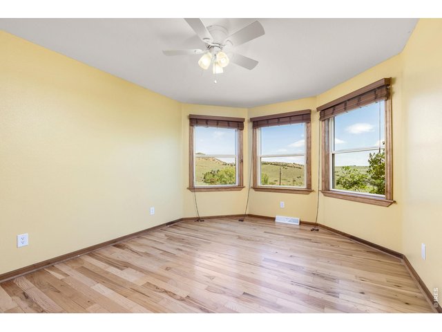 Property Photo 23 Second Upstairs Bedroom - Filled with natural light and continued hardwood flooring.