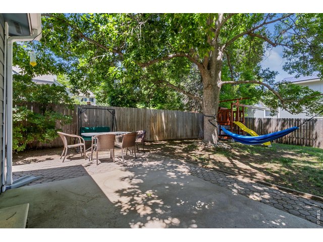 Property Photo 22 The backyard patio is ready for summer barbecues, outdoor dining, and relaxing evenings under the shade trees.