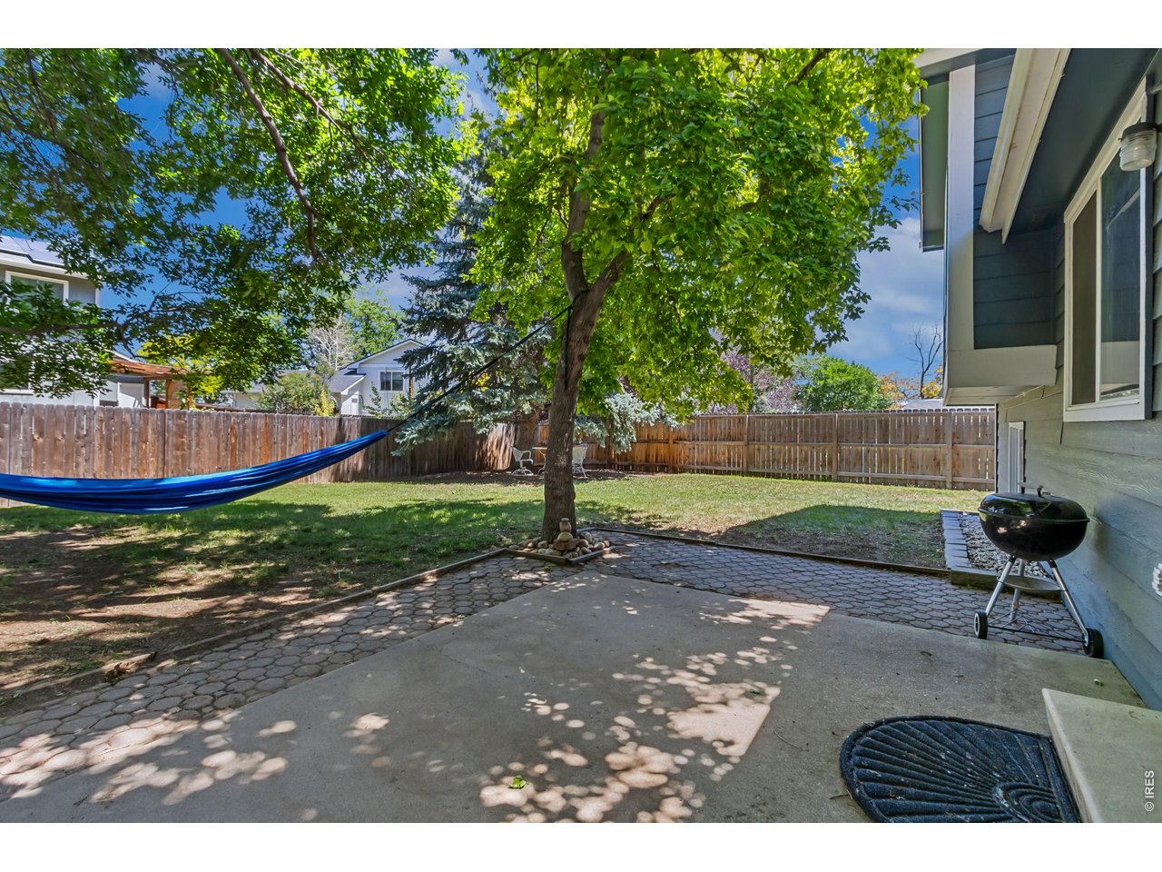 Property Photo 23 A spacious backyard with mature trees offers room to play, garden, entertain, or simply enjoy the outdoors.