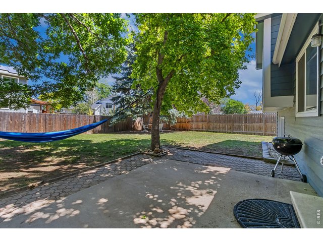 Property Photo 23 A spacious backyard with mature trees offers room to play, garden, entertain, or simply enjoy the outdoors.