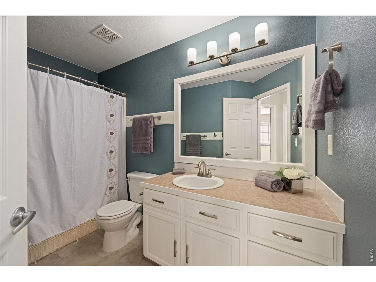 Bathroom #2 with double shower head, painted cabinets and updated handles, faucet and towel bars