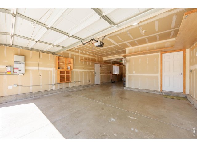 Property Photo 30 3 car tandem garage with extra shelving, folding work-bench, side door and huge window in the 3rd bay.