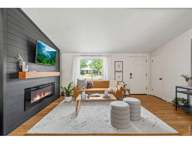 Property Photo 3 Living room anchored by a brand new electric fireplace and dramatic black shiplap accent wall.