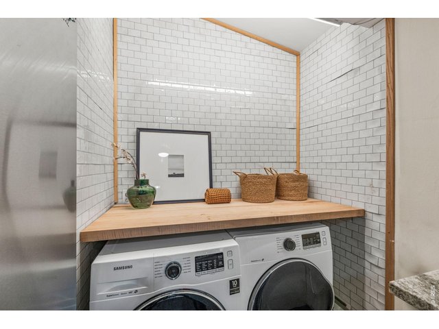 Property Photo 14 Tucked-away laundry nook with subway tile and butcher block counter, full size washer and dryer included.