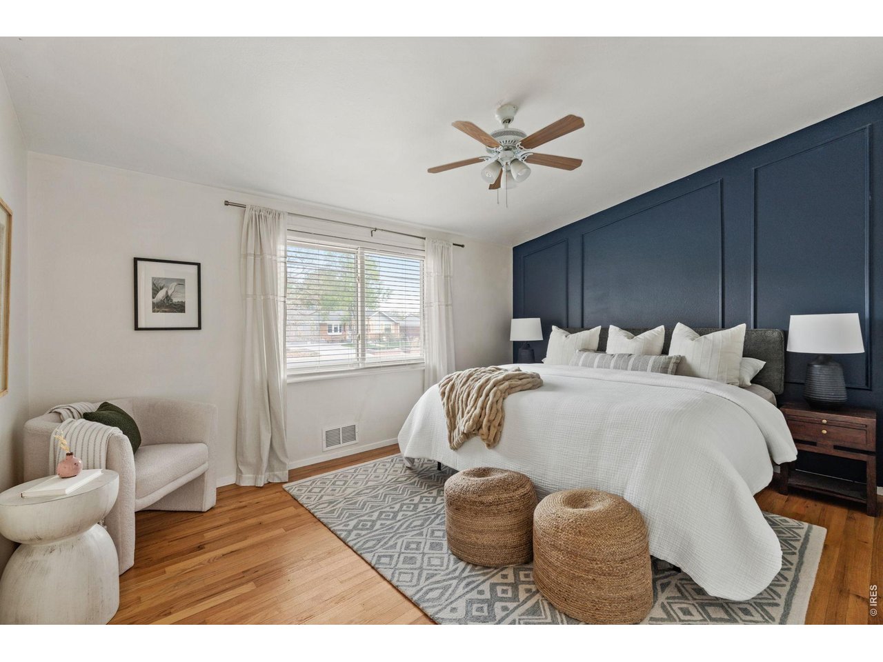 Primary suite features a beautiful navy paneled accent wall and tons of natural light.