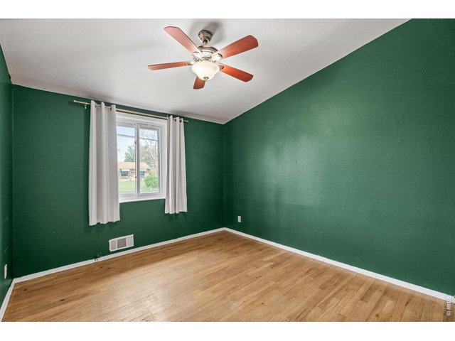 Property Photo 29 bedroom with deep emerald green accent walls, original hardwood floors, and great closet space.