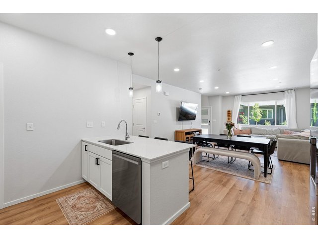 Property Photo 16 Stylish kitchen with stainless steel appliances, a dual-fuel gas range with vent hood, white maple cabinetry, subway tile backsplash, quartz countertops, pantry, and large breakfast bar