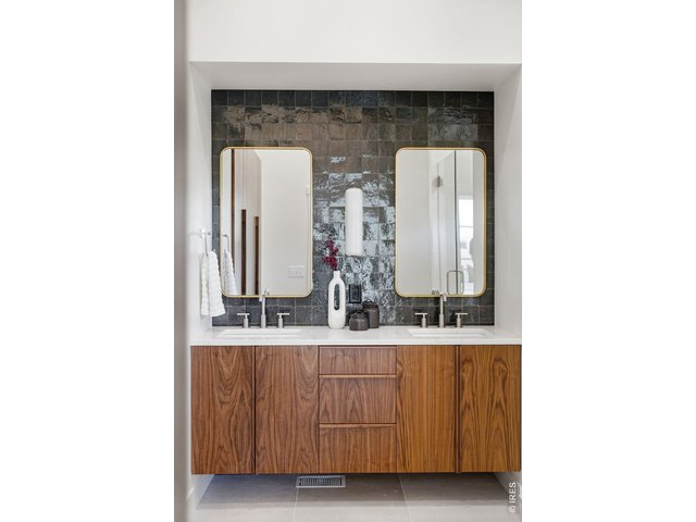 Property Photo 26 Consistent walnut cabinetry details-from the kitchen to the wardrobes to the custom vanity-create a timeless, cohesive look. Built-in wardrobes line left wall.