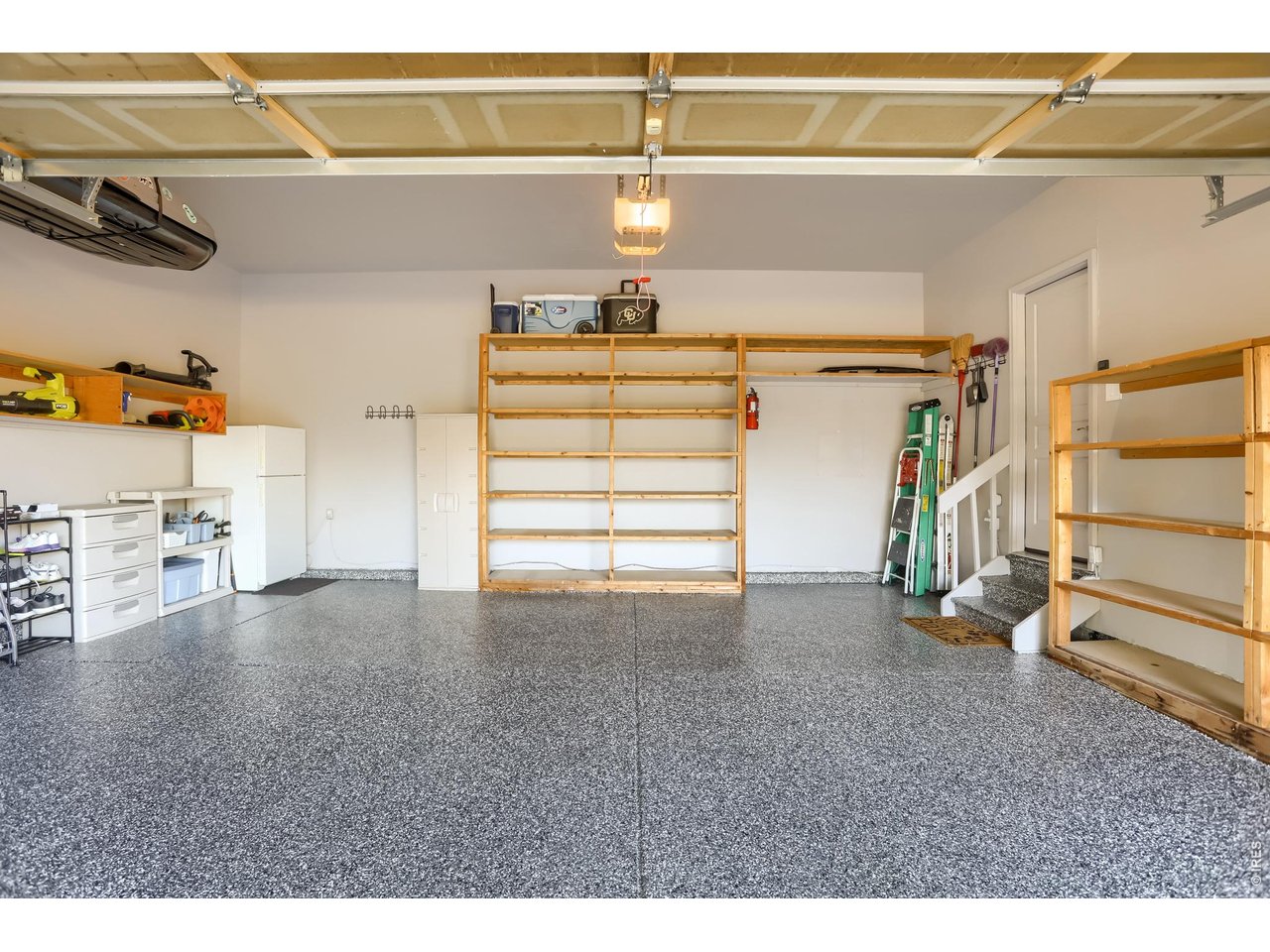 Garage with epoxy flooring/built-in shelving/hot and cold water spigots