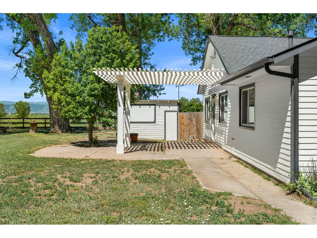 Property Photo 39 The shed behind the pergola features a TV behind the dropdown window for outdoor entertainment