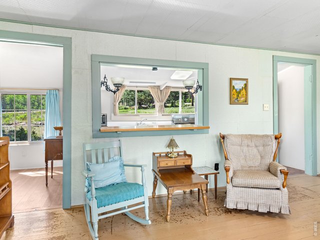 Property Photo 9 The kitchen features a pass through opening to the living room, allowing natural light and conversation to flow throughout the cabin